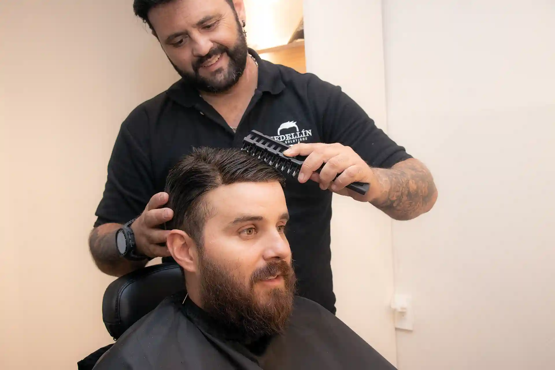 Estilista de Medellín Hair Solutions peinando a un cliente en la barbería